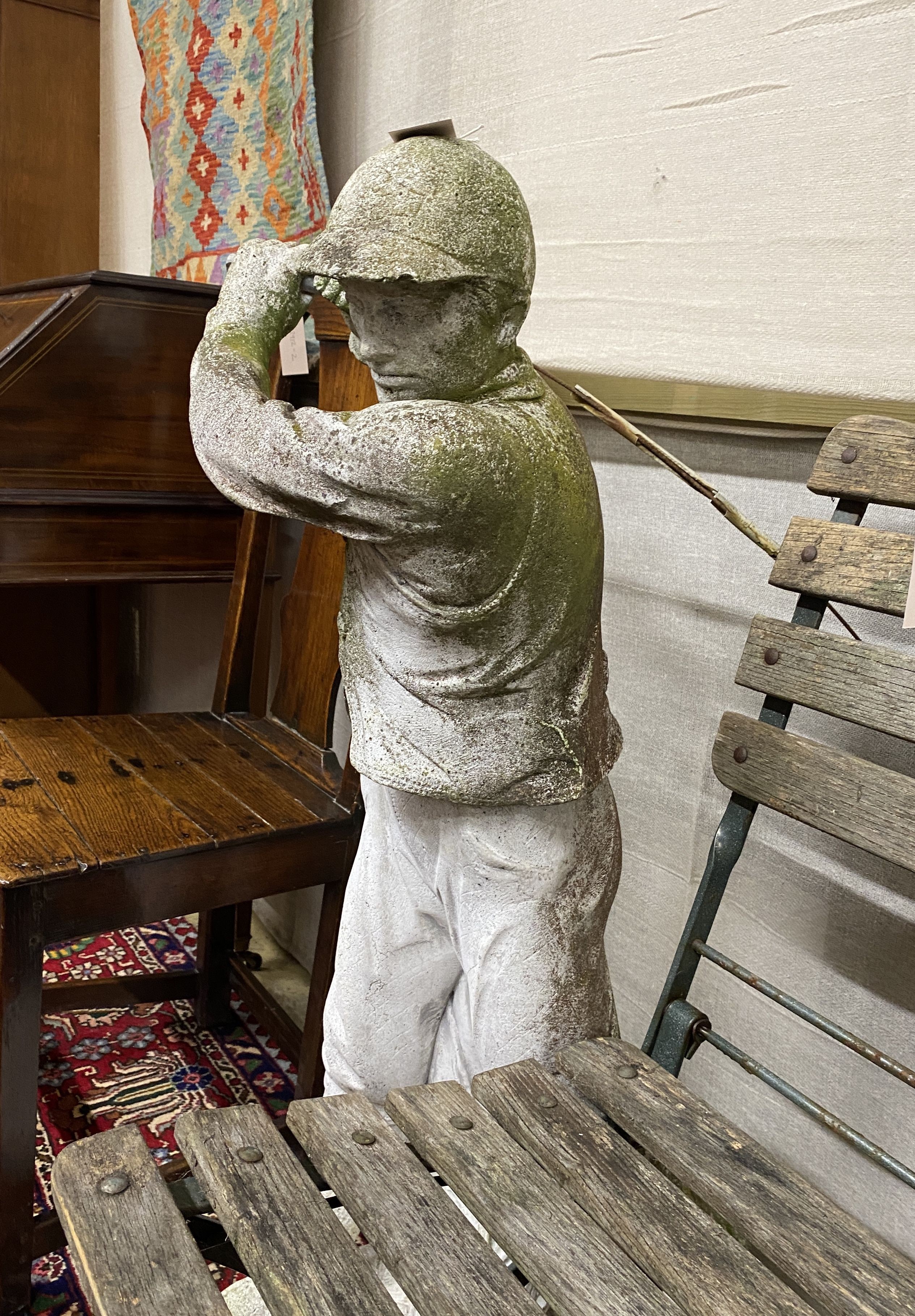 A reconstituted stone garden ornament modelled as a golfer, height 102cm